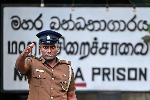 SRI LANKA-PRISON-RIOT A police personnel gestures as he stands outside the Mahara Prison complex following a riot, on the outskirts of Colombo on August 2, 2026