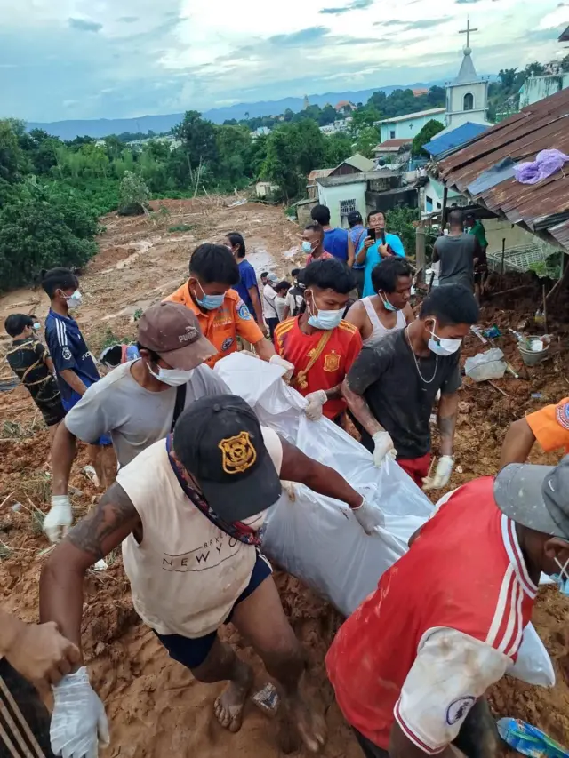 မြေပြိုကျစဉ် သေဆုံးသွားသူရဲ့ အလောင်း သယ်ထုတ်လာတဲ့ လူမှုကူညီရေးအဖွဲ့ဝင်တွေ 