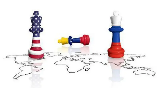 Шахові ферзі у кольрах прапорів США та Росії на тлі мапи світу. Шахова фігура у кольорах венесуельського прапору лежить