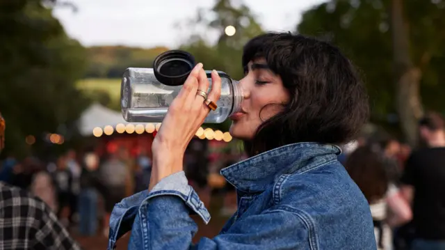 امرأة تشرب الماء في زجاجة
