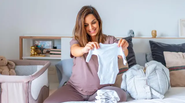 Kobieta w ciąży przygotowuje torbę do porodu w domu