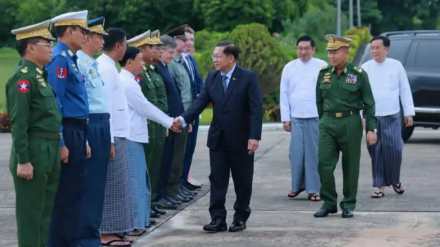 ဗိုလ်ချုပ်မှူးကြီးမင်းအောင်လှိုင်ရဲ့ရုရှားခရီးစဥ်ကိုစစ်ဘက်ထိပ်တန်းခေါင်းဆောင်တွေ လိုက်ပို့နေတာဖြစ်ပါတယ်။ လေယာဥ်ကွင်းမှာ အနောက်တိုင်းဝတ်စုံဝတ်ထားတဲ့ စစ်ခေါင်းဆောင်က လိုက်ပါပို့ဆောင်သူတစ်ဦးကို လက်ဆွဲနှုတ်ဆက်နေပါတယ်။