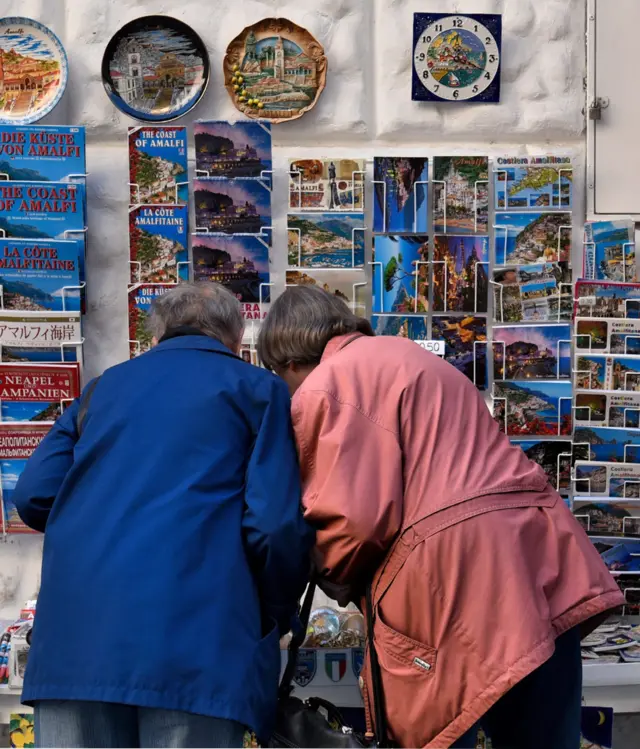 Ljudi ispred sštanda sa razglednicama 