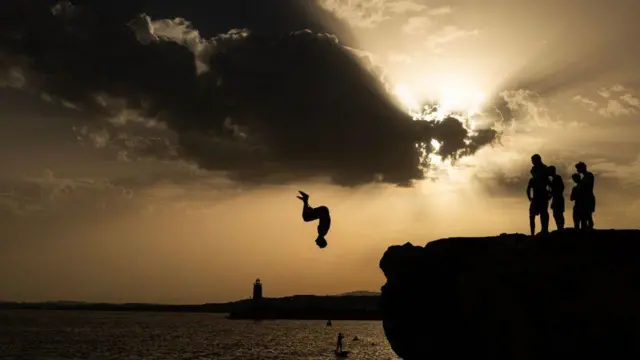 شاب يقفز في البحر الأبيض المتوسط في الريفيرا الفرنسية، 10 أغسطس/آب 2023