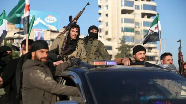 Militantes jihadistas desfilam em um carro pelas ruas de Aleppo. 