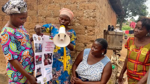 Makavo Annelle Jocelyne, agent de santé communautaire, sensibilise les habitants de son quartier aux risques de la variole.
