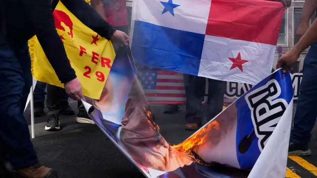 Manifestantes queman una pancarta con la imagen de Donald Trump, durante una protesta frente a la embajada de Estados Unidos en la Ciudad de Panamá, el 24 de diciembre de 2024.