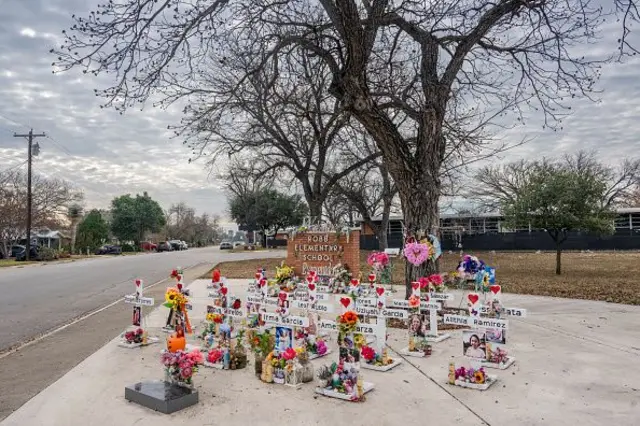 Bir ağacın altında çiçek ve resimlerle süslü haçlar