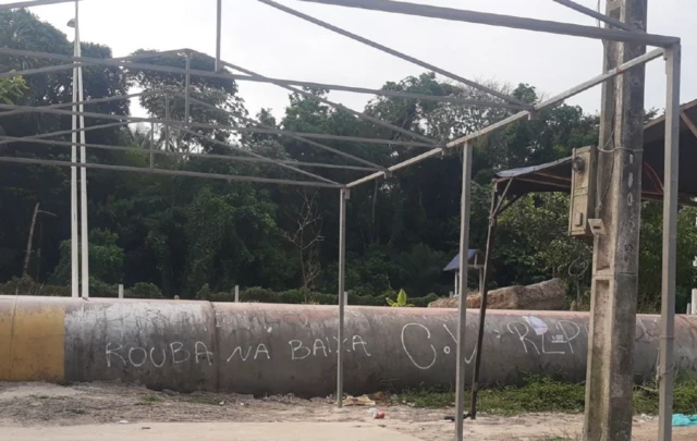 'Rouba na baixa C.V' escrito em cano, perto de mata