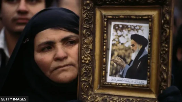 1979-жыл. Тегерандагы аял Ислам ыңкылабы маалында аятолла Хомейнинин сүрөтүн көтөрүп турат.