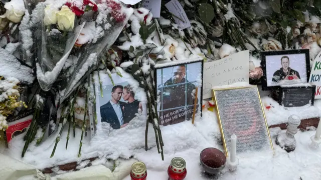 Цветы, фотографии и записки на могиле Навального