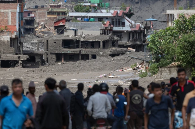 Un grupod e personas miran hacia la zona devastada por la riada en Nuwakot 