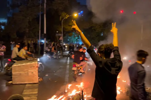 İran'da bir protestoda zafer işareti yapan kadın