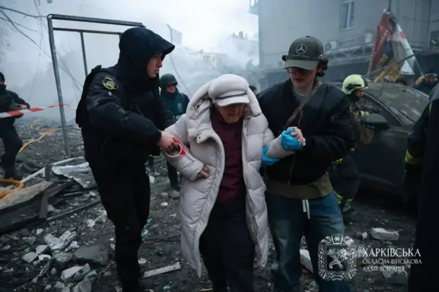 Люди виводять жінку після обстрілу