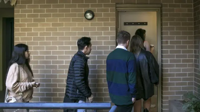 Unos jóvenes junto a un agente inmobiliario visitan una casa.