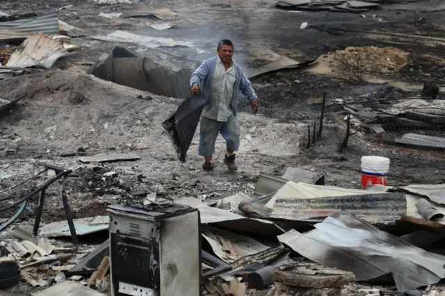 Un hombre camina en medio de las casas que fueron devastada por un incendio en Quilpue, Chile, el 4 de febrero de 2024.