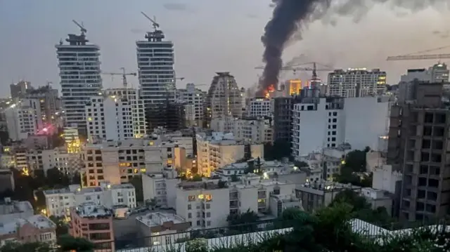 Moshi ukifuka kutoka kwenye vifusi vya jengo la vyombo vya habari vya serikali ya Iran mjini Tehran kufuatia shambulizi la anga la Israel.