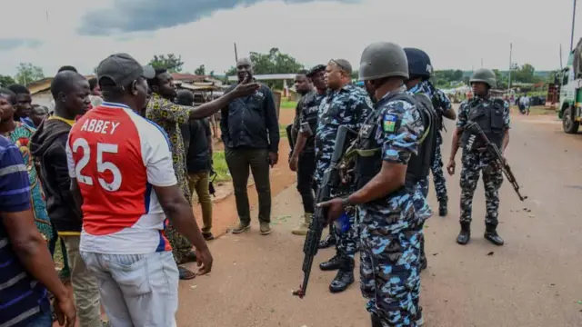 Aworan awọn ọdọ Isanlu Isin ti wọn n ṣalaye ohun to n ṣẹlẹ fun awọn ọlọpaa, awọn ọlọpaa naa gbe ibọn dani