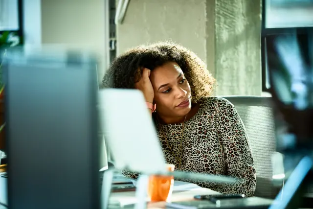 Mulher negraapostas desportivas placardfrente a um computador