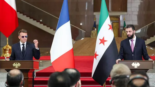 Macron ve Şara'nın ortak basın toplantısı. İki liderin arkasında ülke bayrakları da bulunuyor