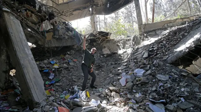 Muškarac stoji na ruševinama