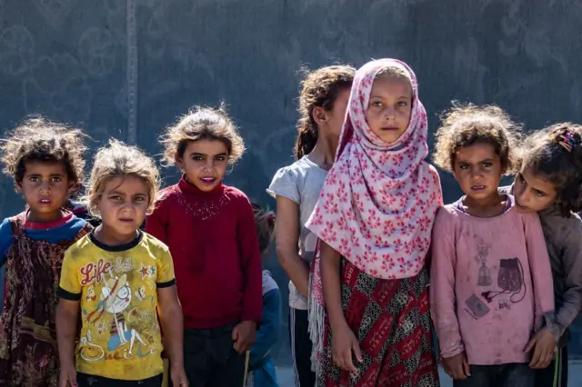 فتيات يقفن في مخيم في محافظة الرقة شمال سوريا، في 10 يوليو 2023