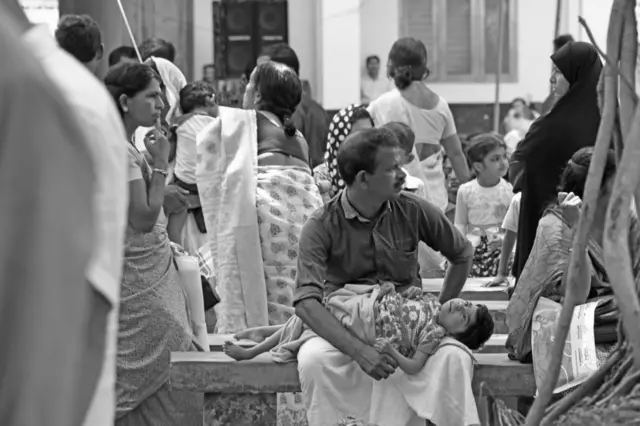 2017 मध्ये कासरगोड येथे एका सरकारी वैद्यकीय शिबिरात मुलाला घेऊन आपला नंबर येण्याची वाट पाहत बसलेले एक वडील. याप्रकरणातील पीडितांची ओळख व्हावी आणि त्यांना वैद्यकीय उपचार आणि नुकसान भरपाई देता यावी या हेतूने हे शिबिर आयोजित करण्यात आले होते.
