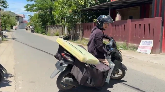 Endro Andani Sianturi, kurir di Aceh sedang membawa paket. Sekarang ia harus mengeluarkan uang lebih sekitar Rp15.000 karena masih mempertahankan pengisian Pertamax.