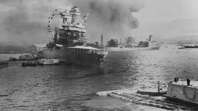 Navios com colunas de fumaça saindo deles após o ataque japonês a Pearl Harbor