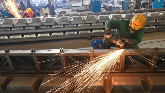 عامل يقوم بعمليات تلميع في ورشة عمل تابعة لشركة تصنيع معدات ميكانيكية في مدينة ويفانغ بمقاطعة شاندونغ الصينية، بتاريخ 27 ديسمبر/كانون الأول 2025.