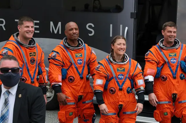 Los cuatro astronaustas vestidos a punto de abordar el cohete que los llevó al espacio.