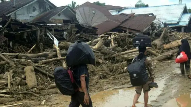 Warga membawa barang-barangnya saat mengungsi dari kawasan yang dilanda banjir bandang mematikan menyusul hujan lebat di Batang Toru, Kabupaten Tapanuli Selatan, Sumatera Utara, Indonesia, 28 November 2025.