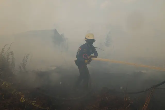 Personel Pemadam Kebakaran Pemerintah Kabupaten Kubu Raya menyemprotkan air ke lahan gambut yang terbakar di belakang Komplek Arwana Indah, Desa Arang Limbung, Kecamatan Sungai Raya, Kabupaten Kubu Raya, Kalimantan Barat, Rabu (5/8/2026). Karhutla yang telah berlangsung selama 12 hari dengan luas diperkirakan lebih dari 10 hektare tersebut semakin mendekati permukiman warga, namun perambatan api ke kawasan perumahan berhasil dicegah oleh tim gabungan pemadam kebakaran dari unsur pemerintah dan swasta.