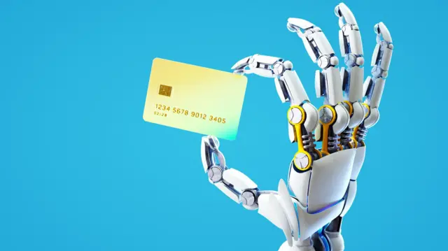 Mão robótica segura um cartão bancário