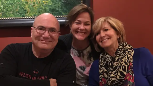 Фотографія усміхнених Кевіна, Деббі та Вел за столиком у ресторані