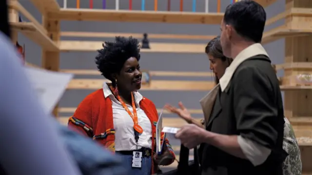 À la fin de la visite, Nadia discute de l'art avec deux visiteurs de la galerie.