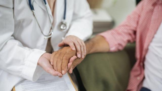 Médico segurando mãotops casino onlineidosa