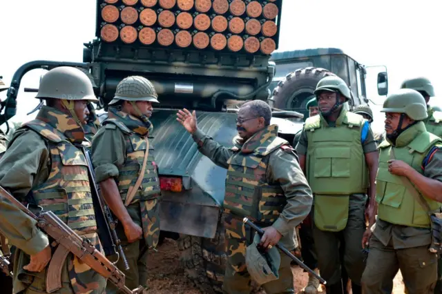 Un commandant parle avec des soldats des Forces armées de la République démocratique du Congo (FARDC), près d'un lance-roquettes multiple mobile à Matombo, à 35 km au nord de Beni, au Nord-Kivu, le 13 janvier 2018, lors de l'opération Sokola 1