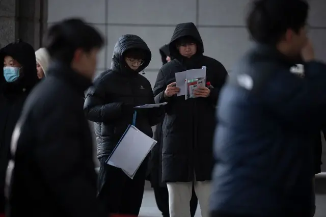 几个身着棉服的男生正在阅读