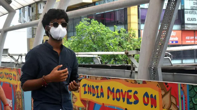 Seseorang pria engenakan masker pelindung meyusul lonjakan kasus varian baru Covid-19 di Kolkata, India, pada 25 Mei 2025.