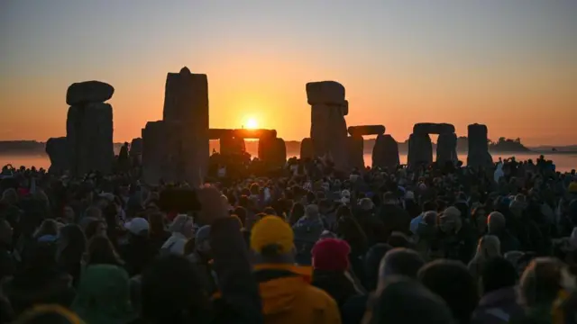 Pengunjung menyaksikan matahari terbit di Stonehenge, pada 21 Juni 2024 di Wiltshire, Inggris.