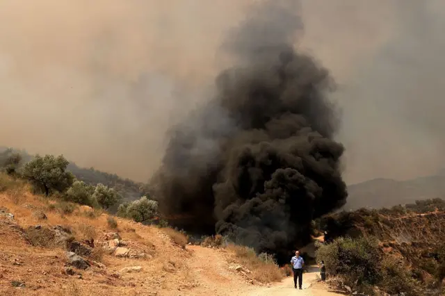 الدخان يتصاعد بسبب حريق هائل في بلدة دلفيني، جنوب شرق ألبانيا، في 13 أغسطس/آب 2025. 