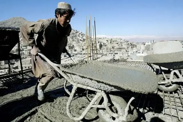 یو ځوان لاس ګاډي کې سمنټ وړي