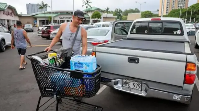 ஹவாய் தீவில் வசிக்கும் ஒருவர் தனது வாகனத்தில் தண்ணீர் மற்றும் பிற பொருட்களை ஏற்றுகிறார்.