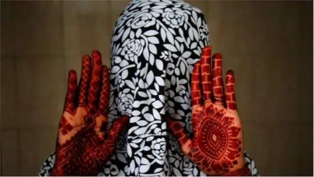 Woman decorate her hand wit henna for di Eid festival