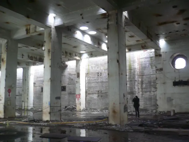 Una persona toma fotografías en un edificio de altas columnas de la central de Lemóniz. 