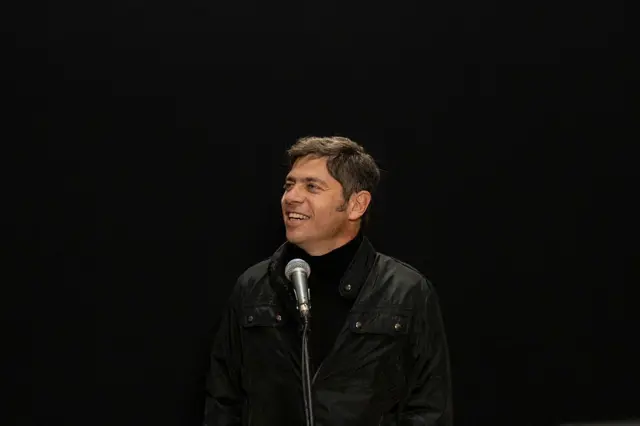Axel Kicillof sonríe frente a un micrófono. 