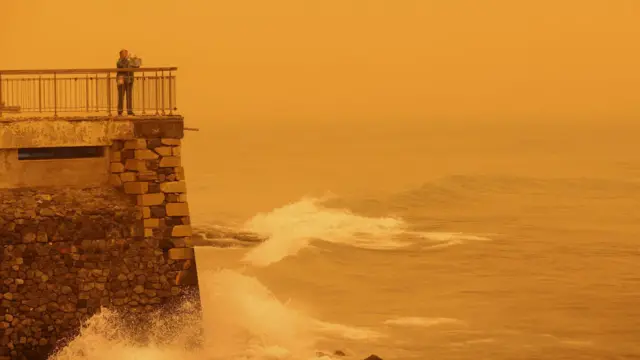 Жена фотографише жуц́каст хоризонт узрокован пешчаном прашином из Сахаре, услед јаких јужних ветрова, у Ираклиону, на острву Крит