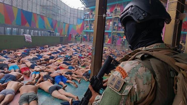 Detentosjogos online para jogarbruços observados por um homem com uniforme militar armado