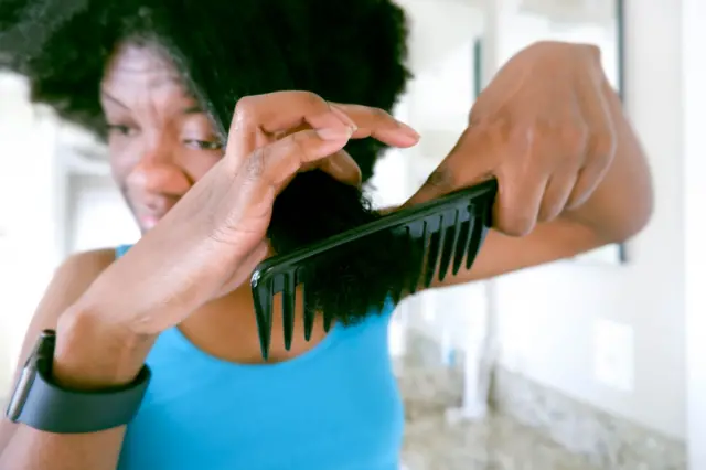 Femme qui se peigne ses cheveux 